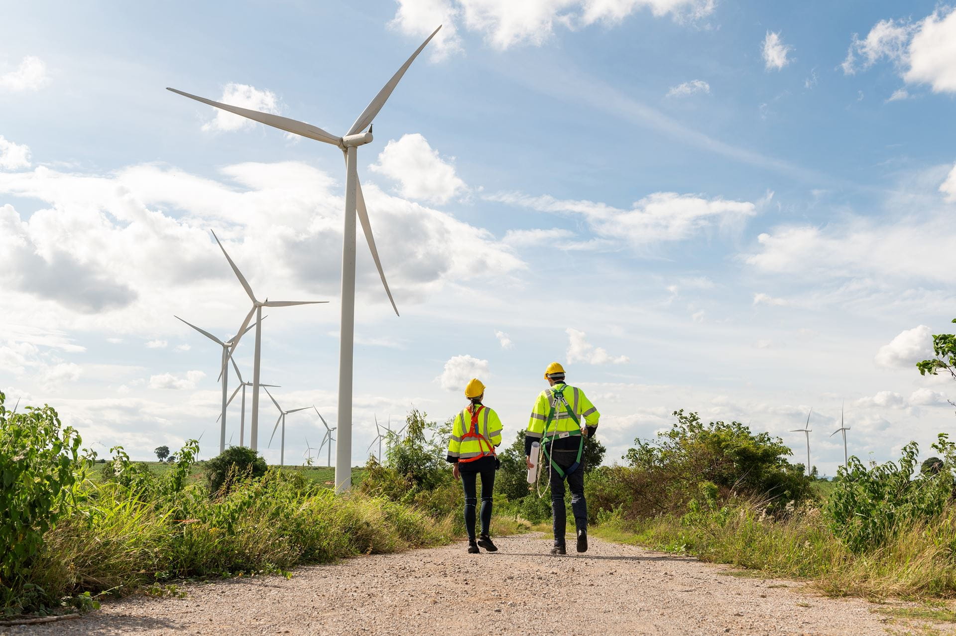 Twee mensen met windmolens op de achtergrond Twee mensen met windmolens op de achtergrond