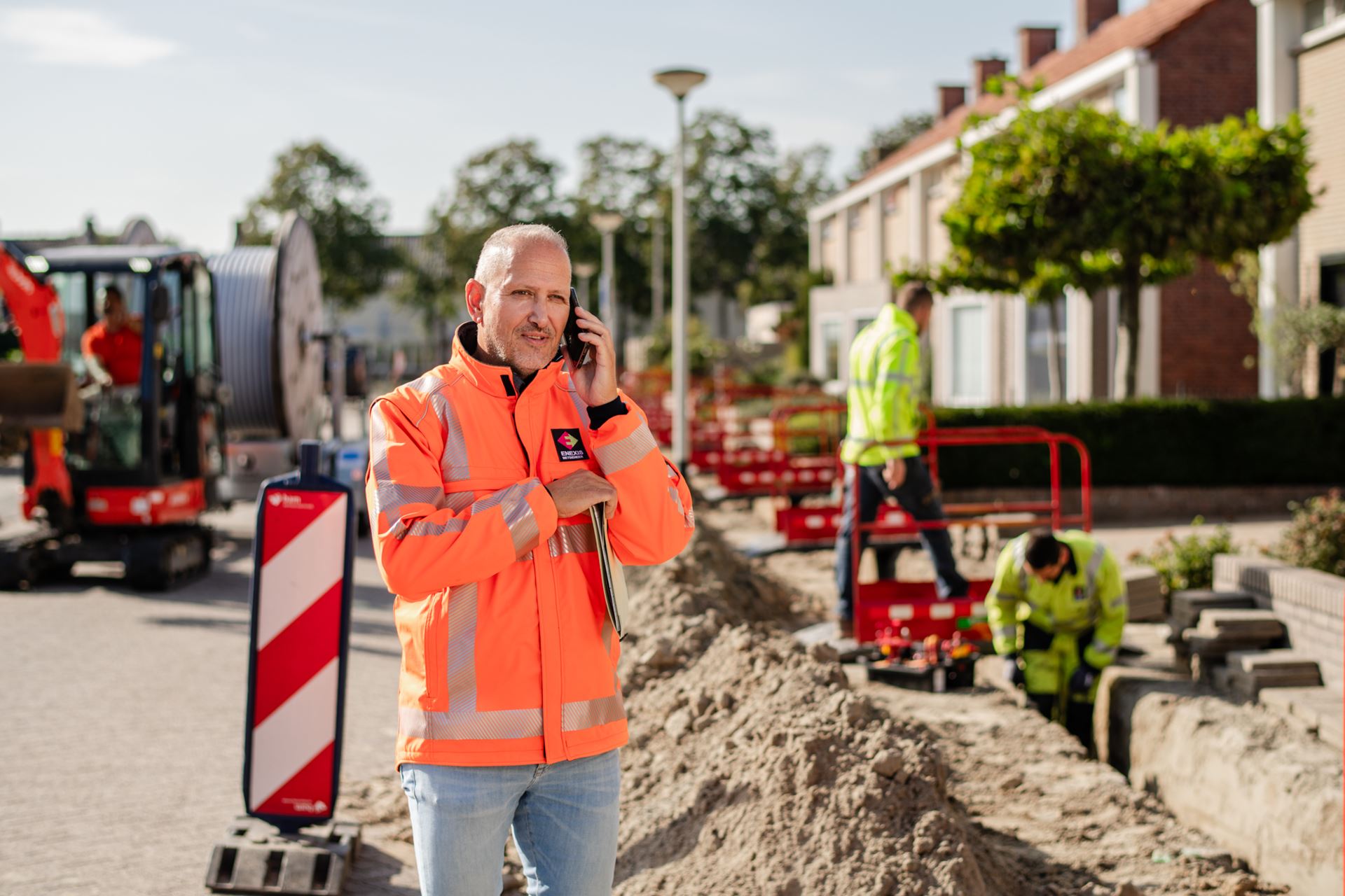 Een Enexis monteur is aan het telefoneren Een Enexis monteur is aan het telefoneren